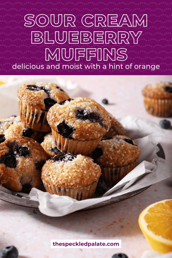 A plate stacked full of blueberry muffins with the text sour cream blueberry muffins delicious and moist with a hint of orange