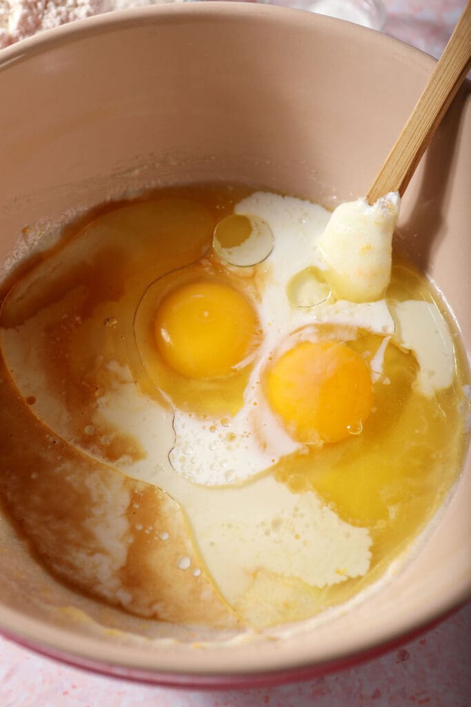 Eggs and other wet ingredients added to a bowl before mixing