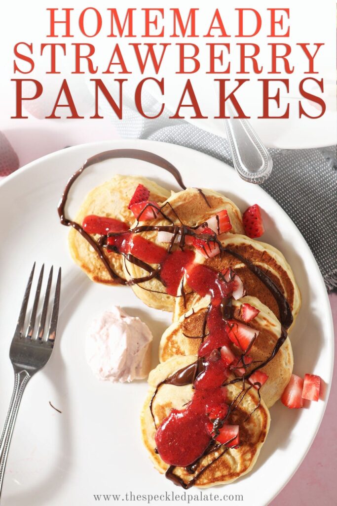 Pancakes topped with strawberries, chocolate and strawberry sauce with the text 'homemade strawberry pancakes'