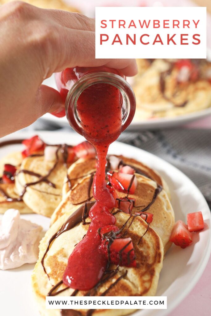 Strawberry sauce pours on top of pancakes with the text 'strawberry pancakes'