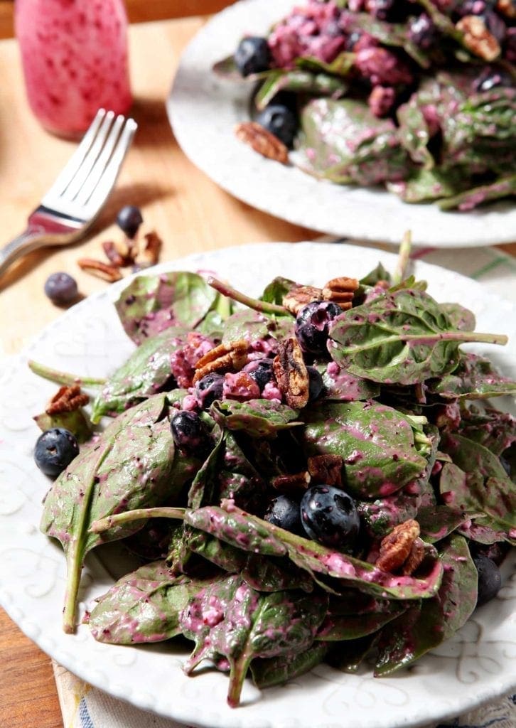 blueberry pecan feta salad on white plates with a silver fork