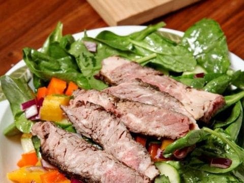 A plate of food on a table, with Salad and Steak