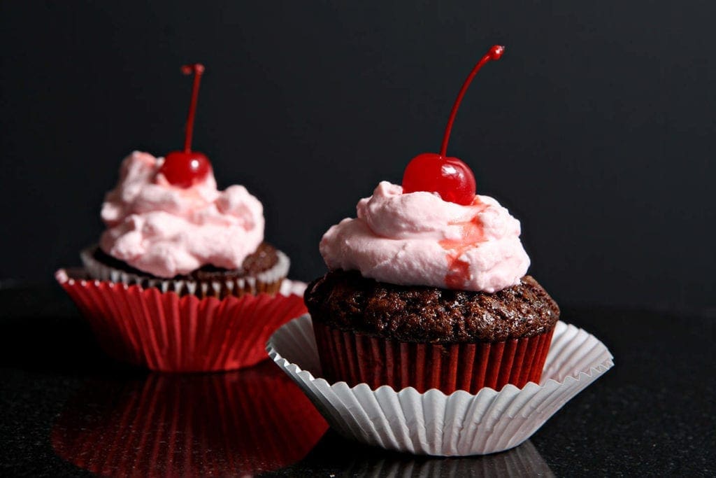 side view of chocolate cupcakes with cherries