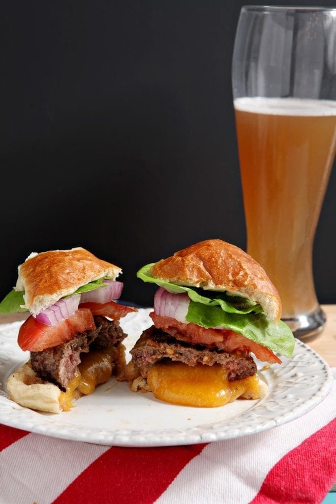 A close up of a sandwich and beer, with Juicy Lucy burger