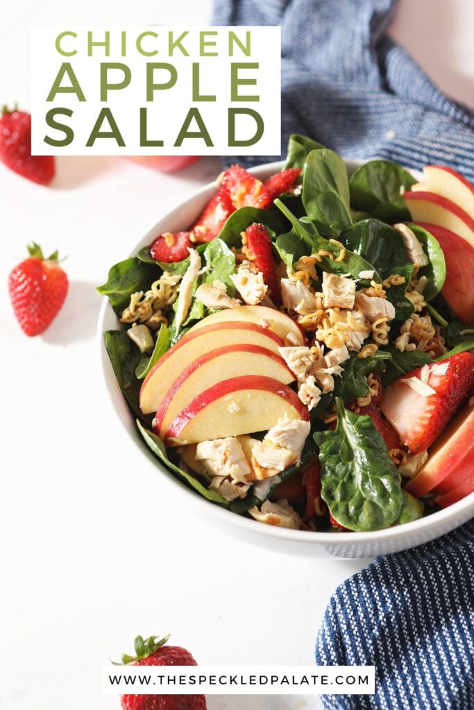 A bowl of a fruit and spinach salad with the text 'how to make chicken apple salad'