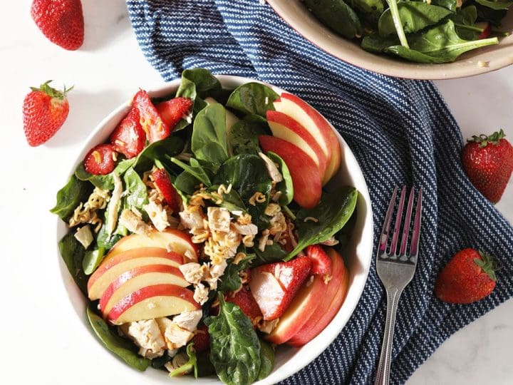 Two bowls of Chicken Spinach Salad with a blue napkin