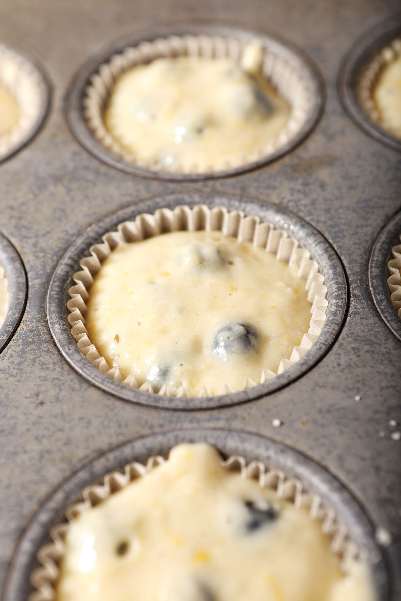 Blueberry lemon muffin batter in a muffin tin before baking