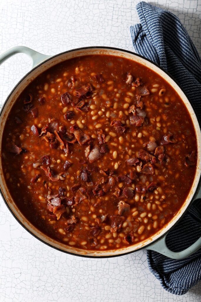 Close up of a pot of beans with sauce before baking in the oven