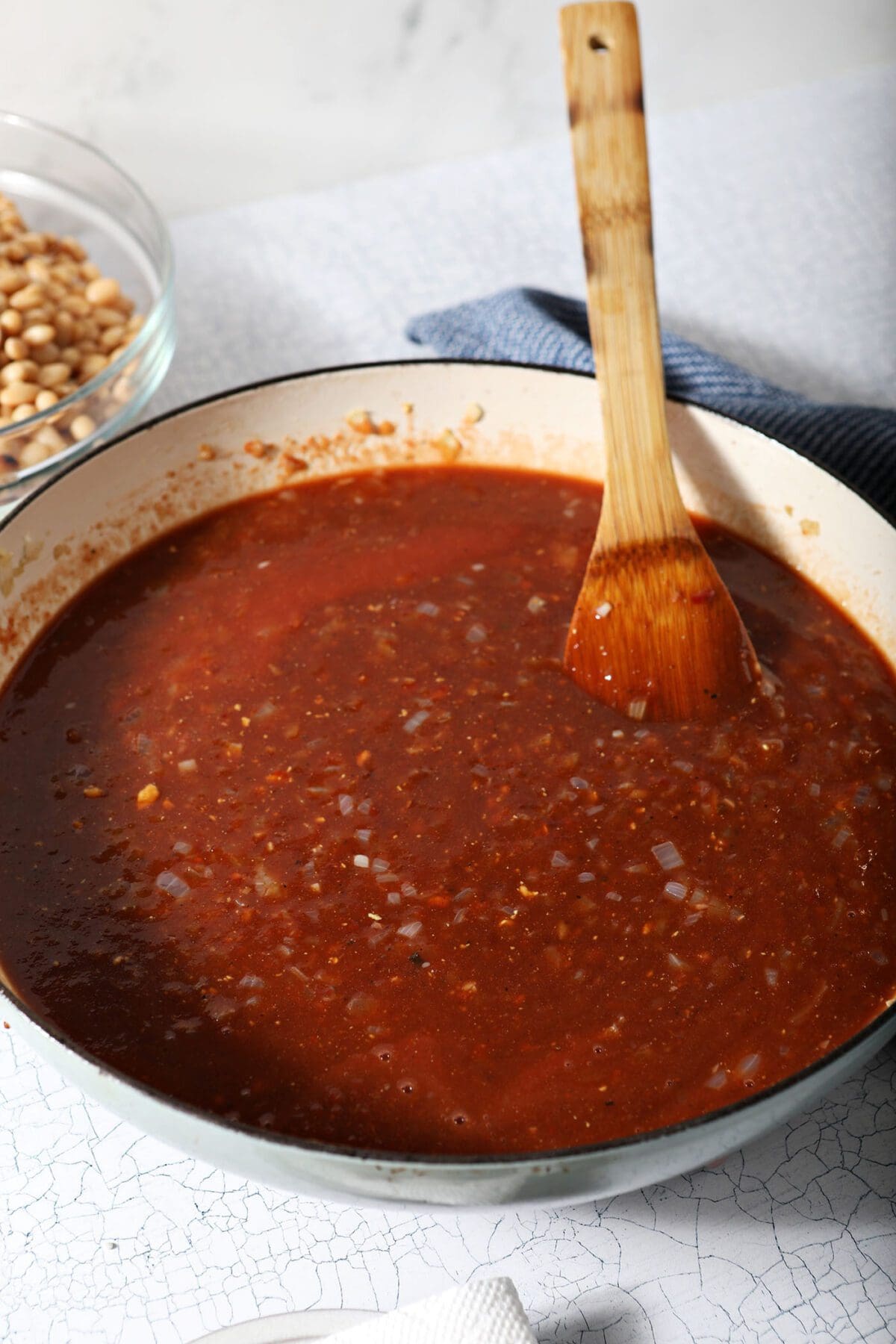 Baked bean sauce in a pan with a wooden spoon