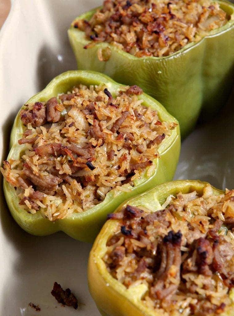 Three Turkey Jambalaya Stuffed Bell Peppers sit inside a baking dish after cooking.