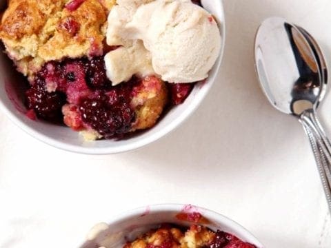 Two bowls of Blackberry cobbler with ice cream on top