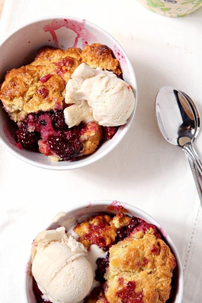 Two bowls of Blackberry cobbler with ice cream on top 