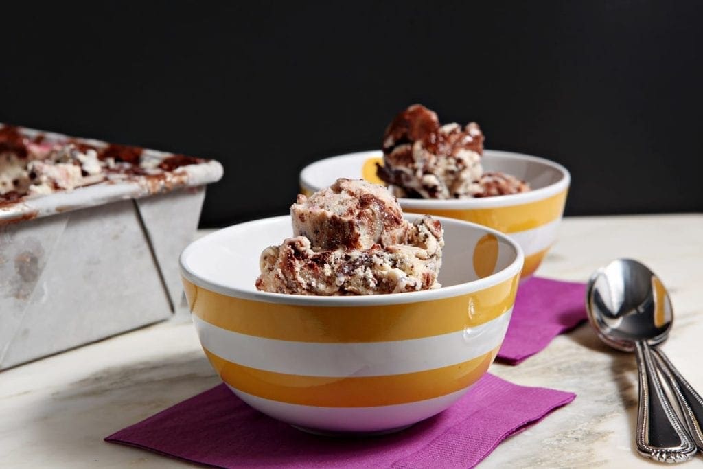 Close up of two striped bowls filled with gelato on purple napkins 