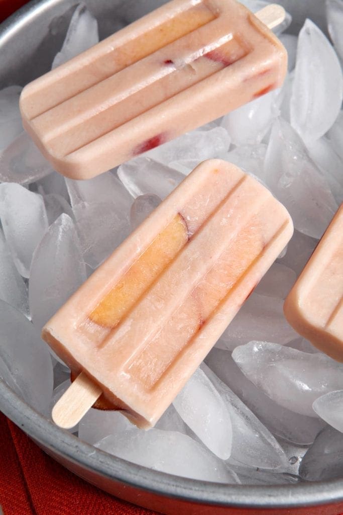 Close up of popsicles laying over ice cubes 