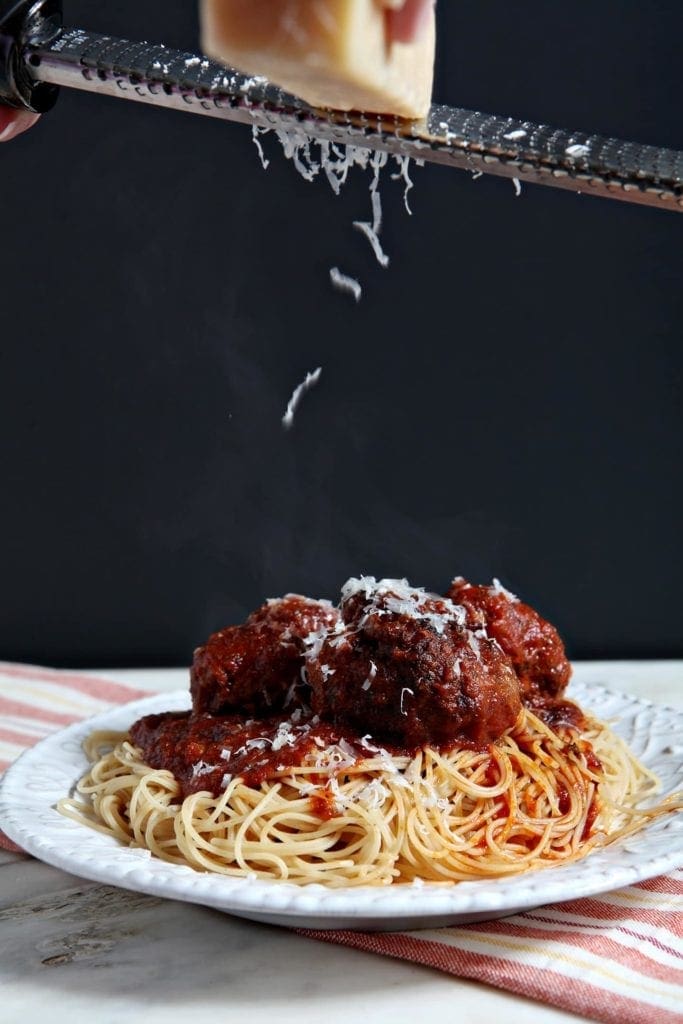 Parmesan cheese sprinkled over a plate of Spaghetti and Meatballs