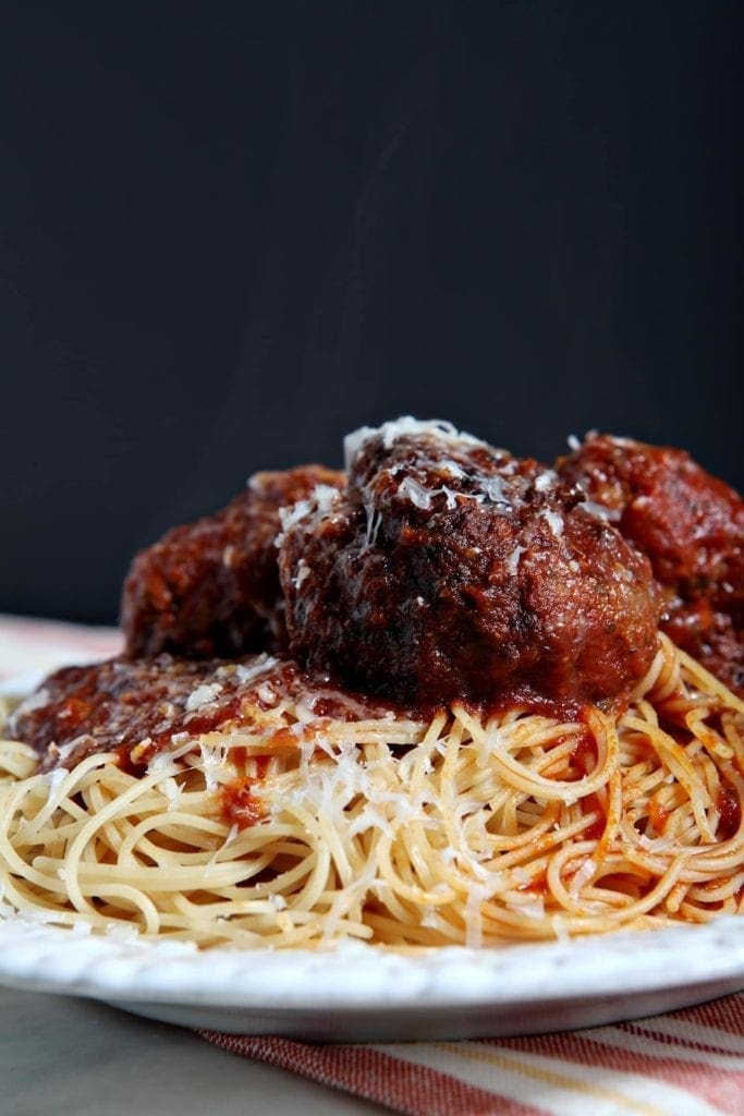 Close up of spaghetti and meatballs on white plate 