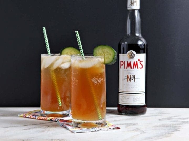 two glasses of pimm's with green straws