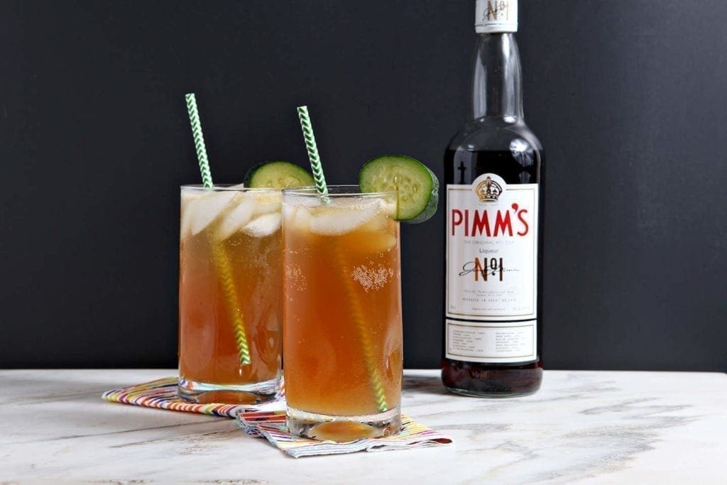 two glasses of pimm's with green straws