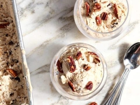 Scoop of ice cream in 2 glass bowls with spoons