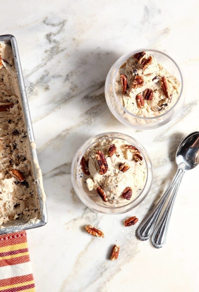 Scoop of ice cream in 2 glass bowls with spoons