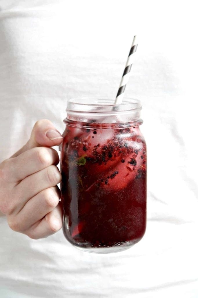 One Blackberry Mint Spritzer being held in hand before drinking