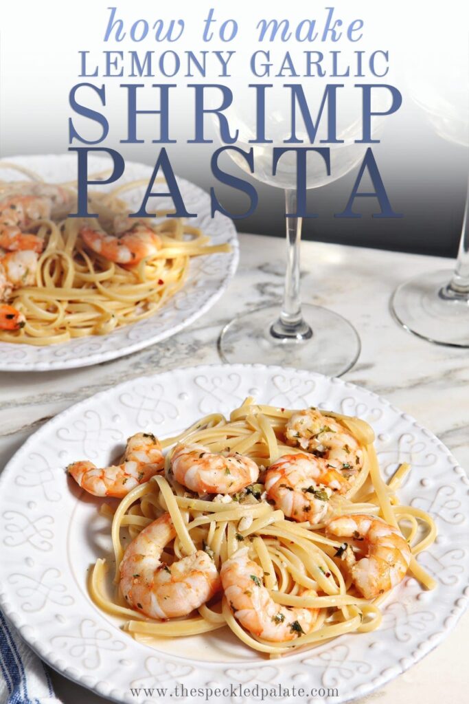 Lemon Shrimp Pasta on a white plate with a fork on marble with a glass of wine with the text 'how to make lemon garlic shrimp pasta'