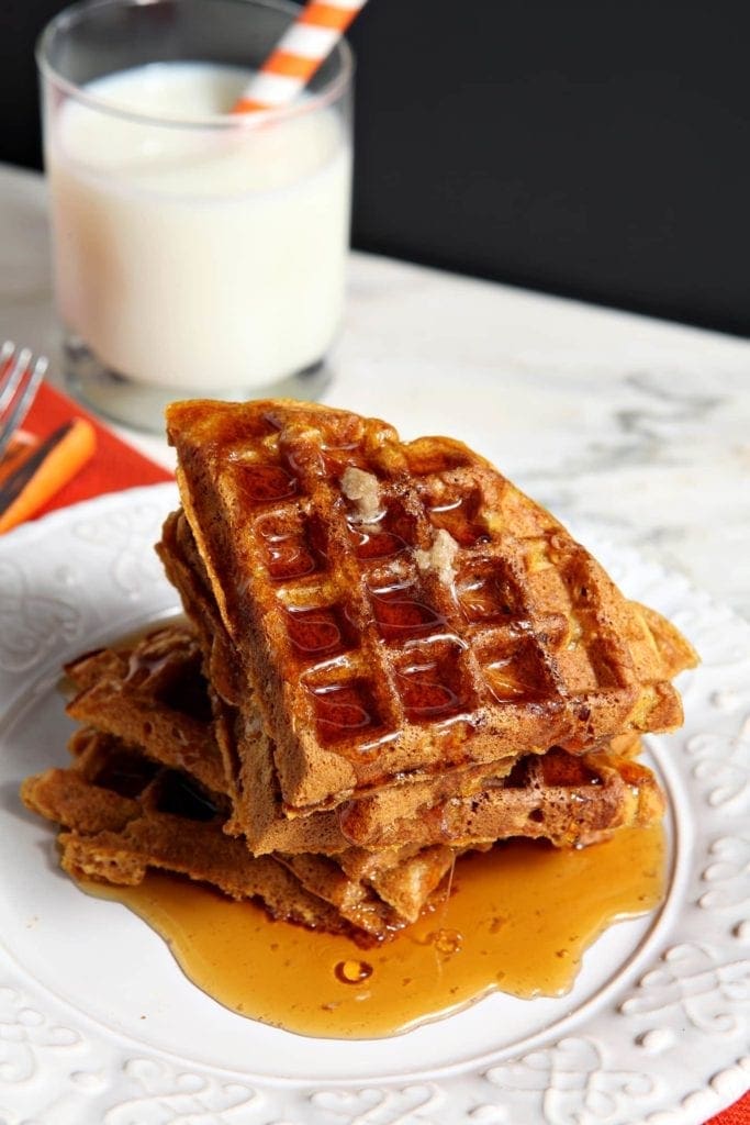 Close up of maple syrup on top of stacked, sliced waffles 