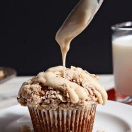 Maple Cream Cheese Glaze is drizzled onto Pumpkin Brown Butter Streusel Muffins