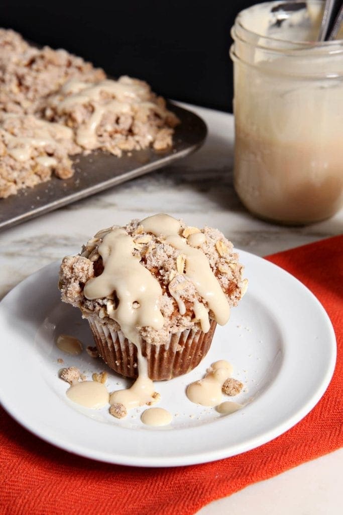 Muffin on top of white plate drizzled with glaze