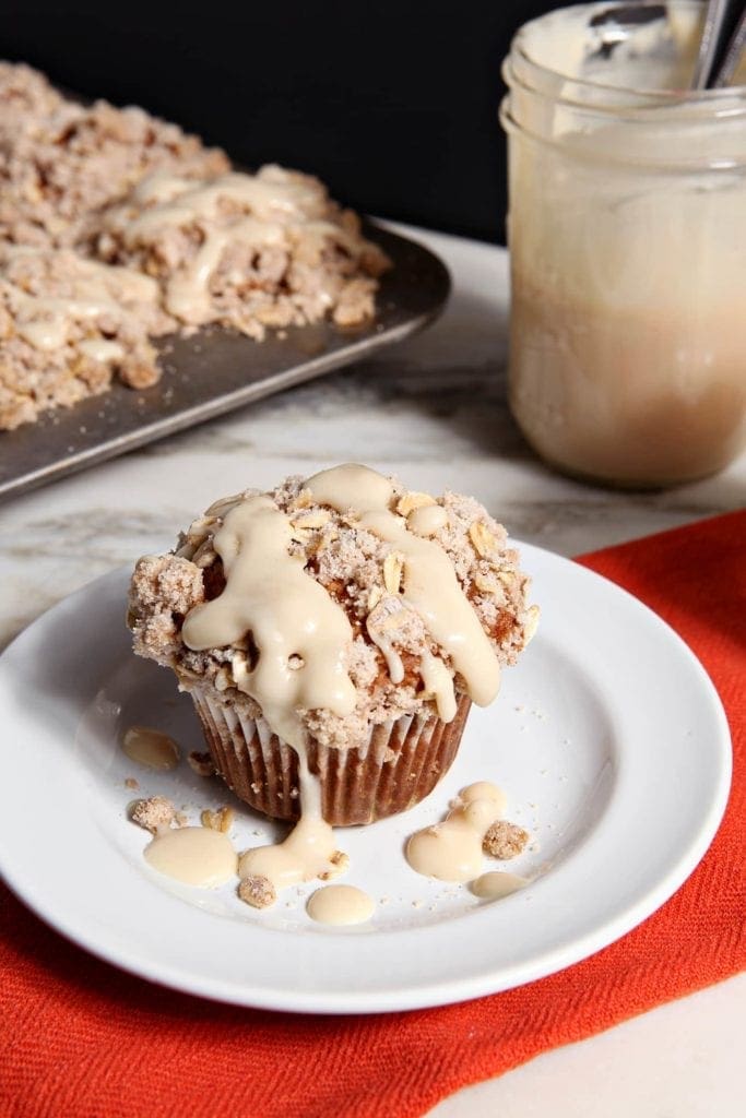 Muffin on top of white plate drizzled with glaze 