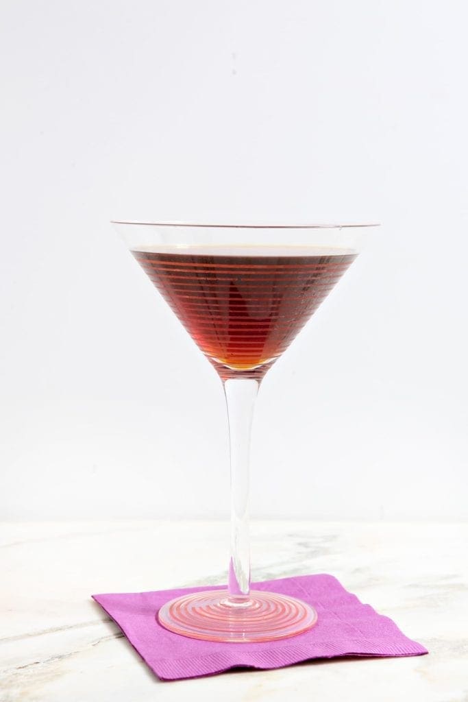 Cocktail glass filled with Siciliano on purple napkin 