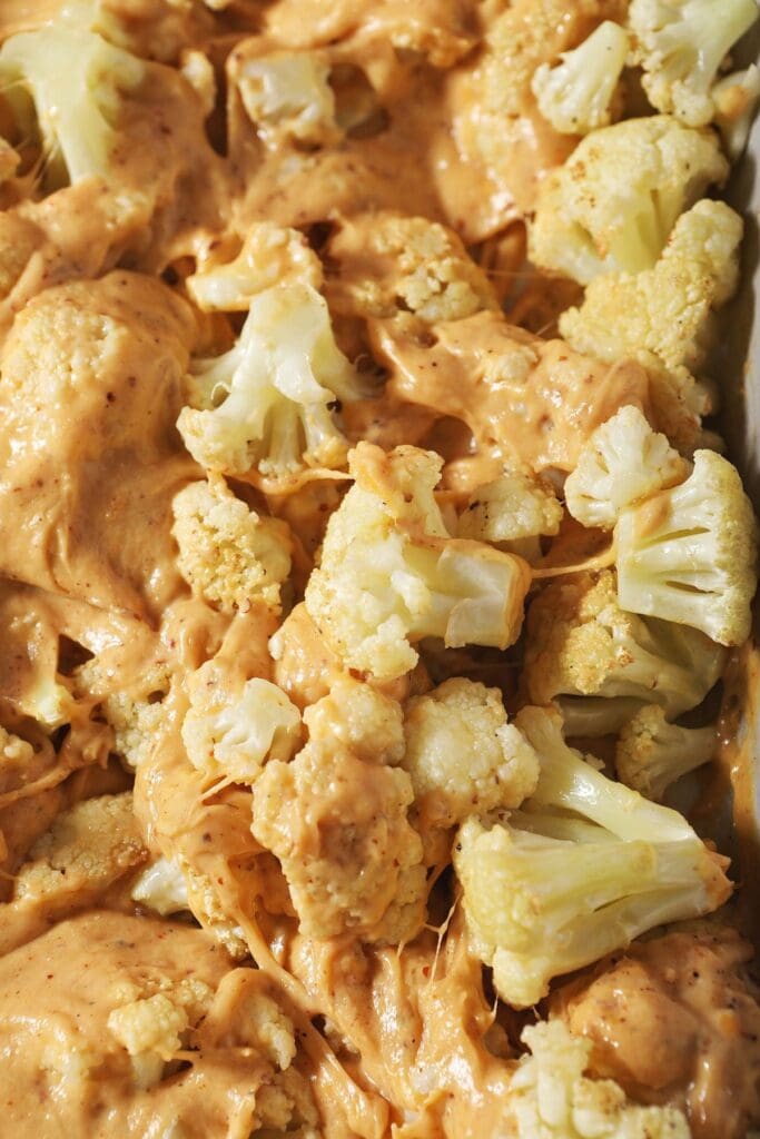 Close up of cauliflower mixed with cheese sauce before baking