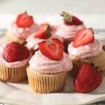 A white platter of decorated Strawberry Cupcakes