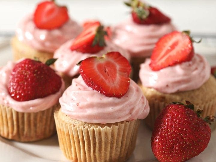 A white platter of decorated Strawberry Cupcakes
