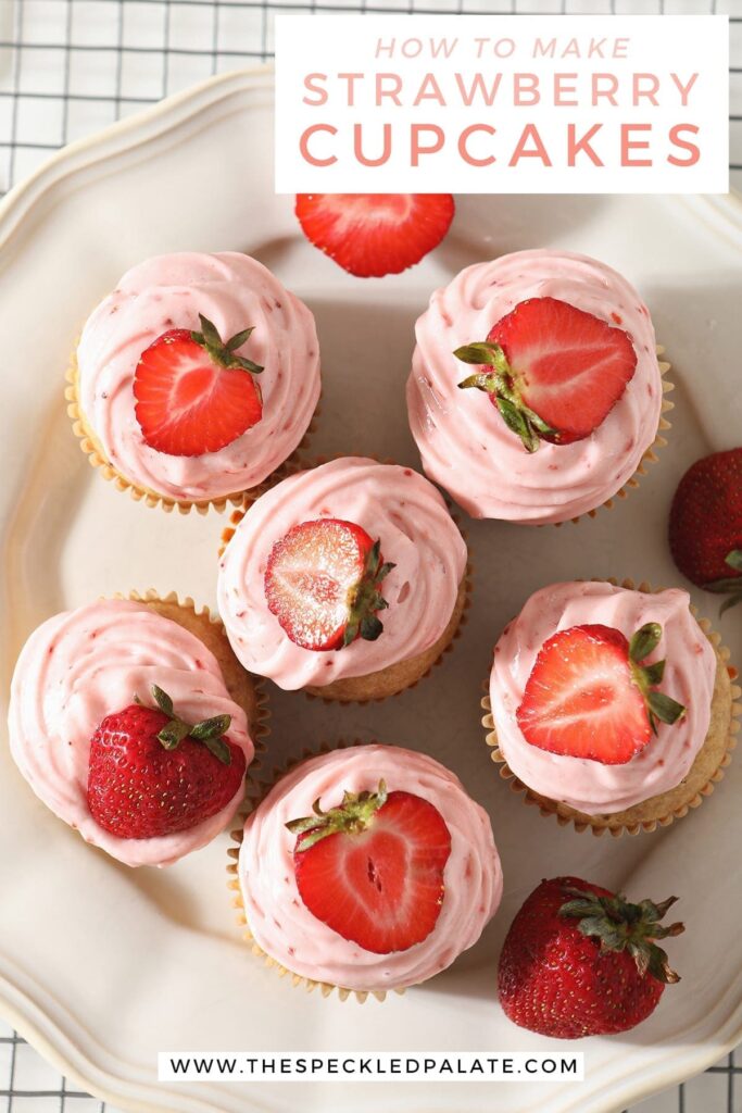 Overhead of a white platter holding six decorated Strawberry Cupcakes with the text 'how to make strawberry cupcakes'