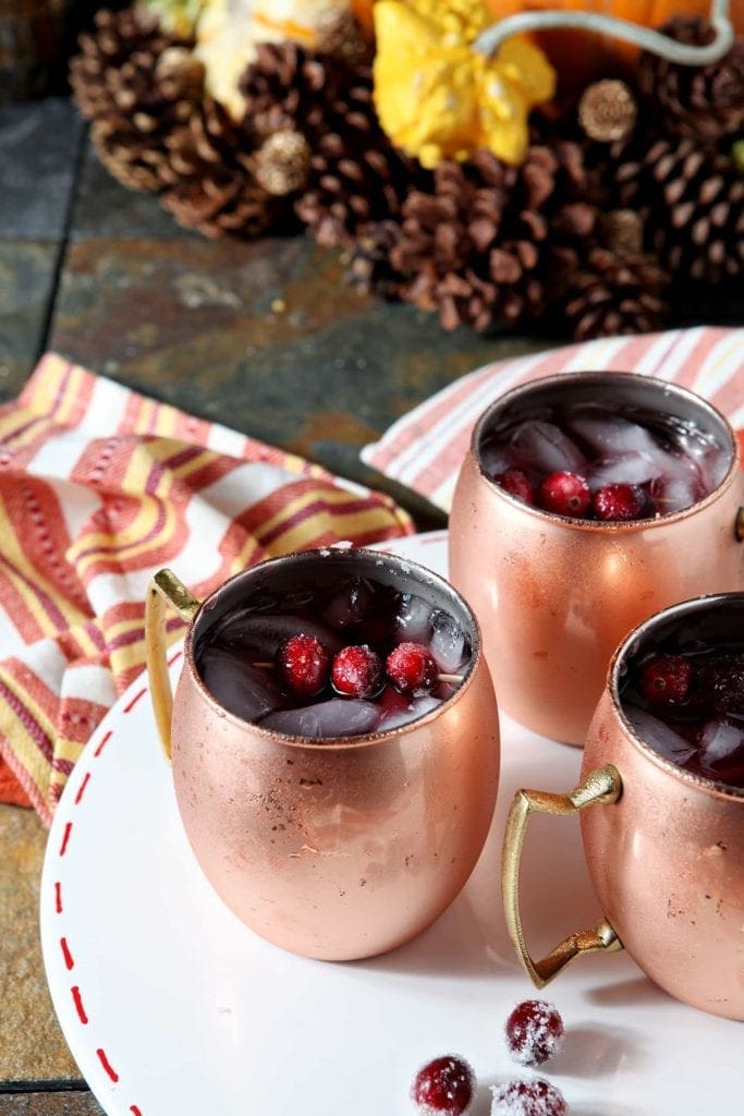 Three Cranberry Mules are served on a white platter