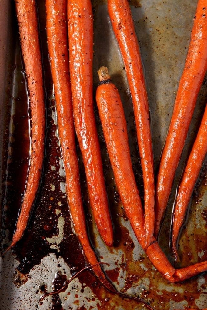 Overhead close up of honey roasted carrots on baking pan 