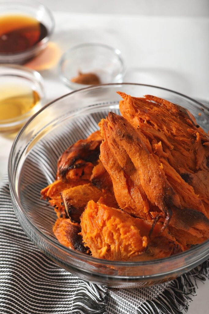 Baked sweet potatoes in a glass bowl on marble