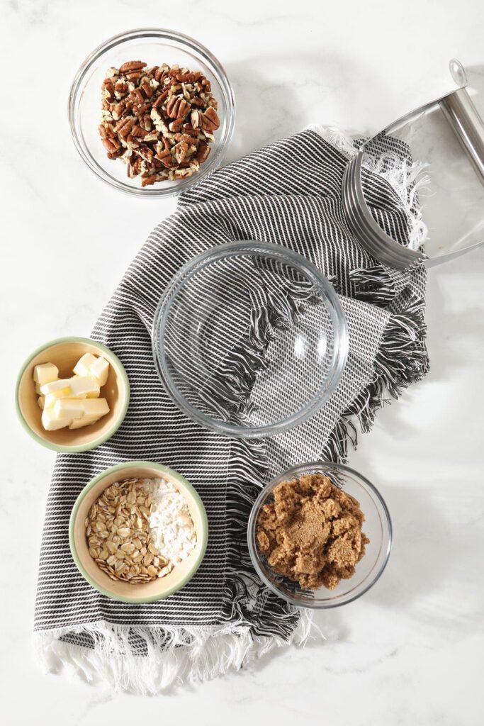 Streusel ingredients in bowls before mixing on a grey striped towel