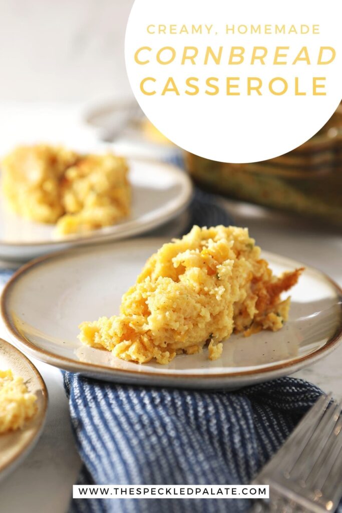 Closeup image of a scoop of creamy cornbread casserole on a white pottery plate on top of a blue towel with the text 'creamy homemade cornbread casserole'