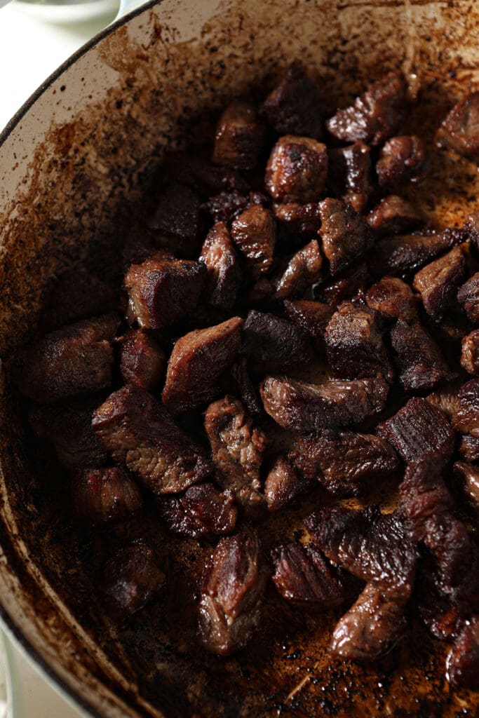 Seared beef stew meat in a skillet