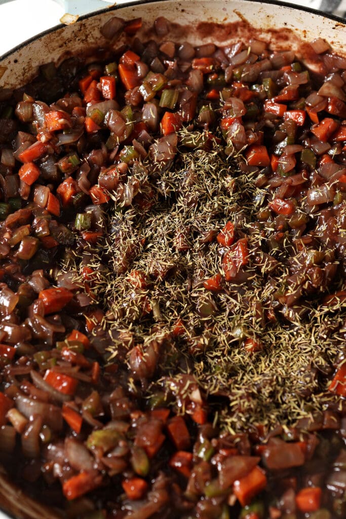 Thyme on veggies and wine in a skillet