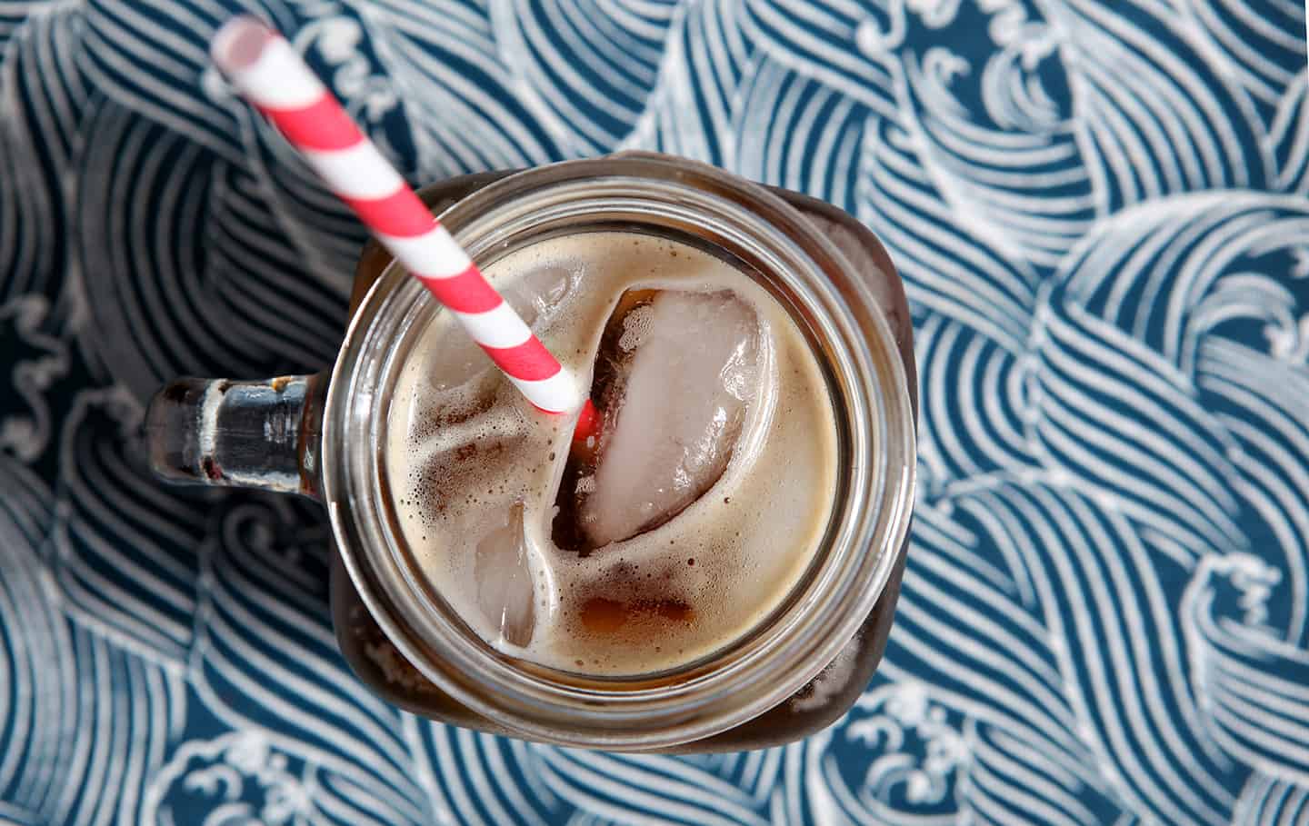 An overhead of the Boyfriend Irish Coffee in a mason jar glass, shown on a patterned blue napkin