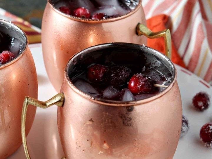 Close up of three Cranberry Mules, shown on a white serving platter