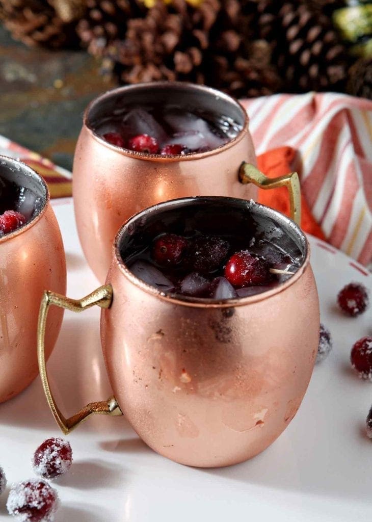 Close up of three Cranberry Mules, shown on a white serving platter