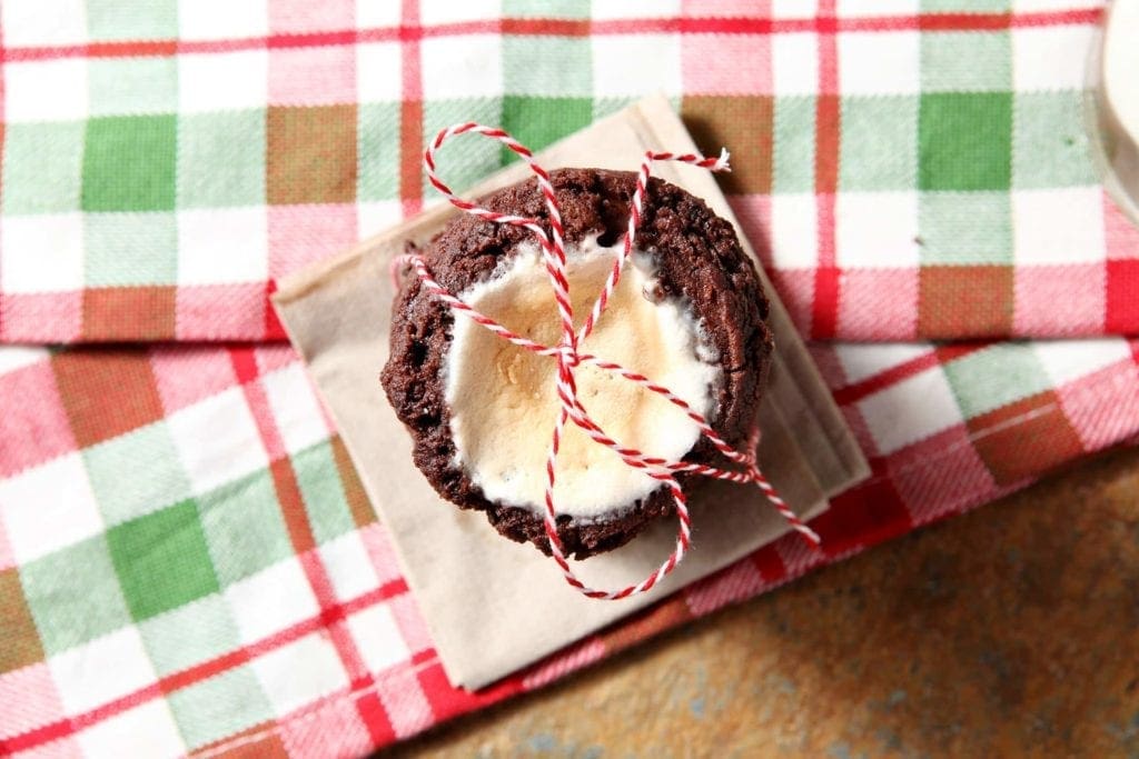 Overhead view of hot cocoa cookies on linens wrapped in a bow
