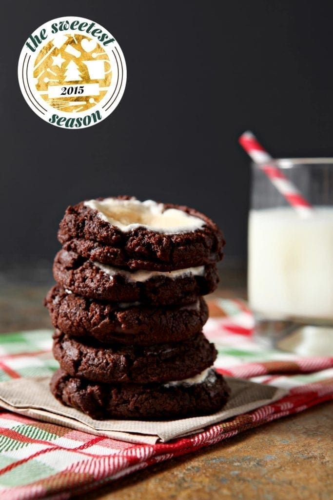 Stack of cookies on linens with a glass of milk 