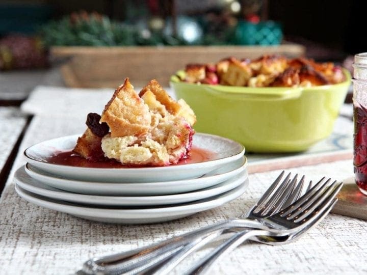French toast casserole on stack of plates in front of casserole dish