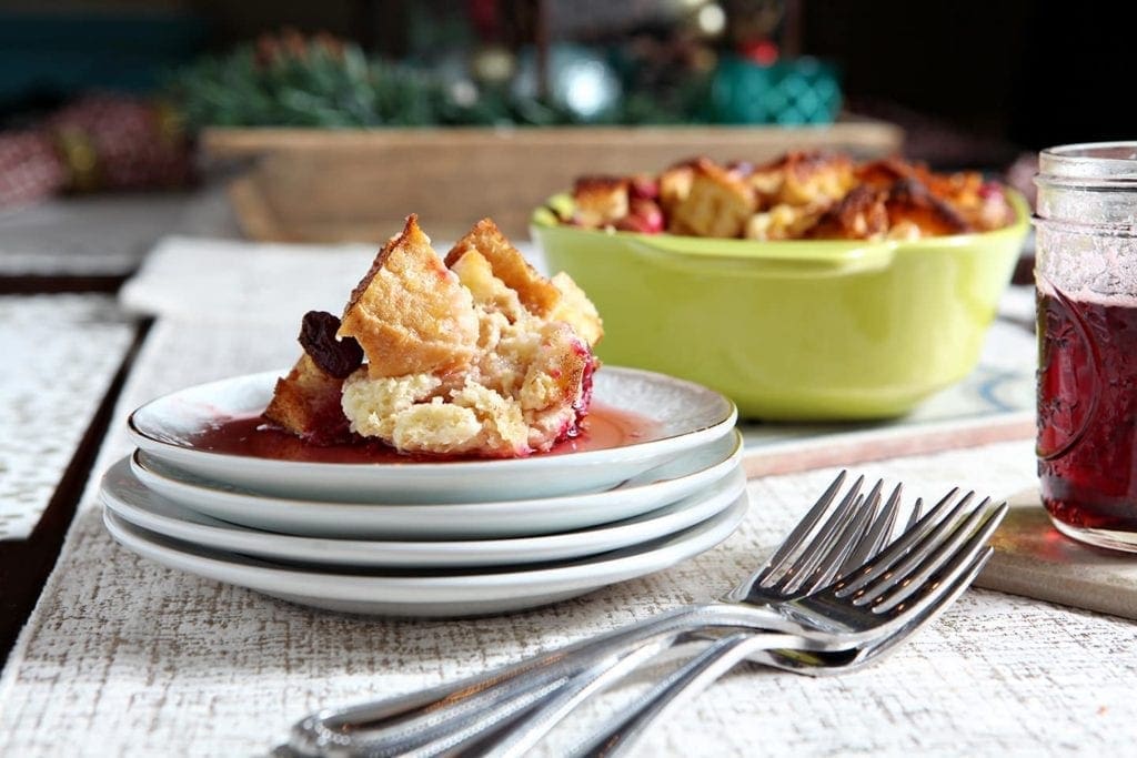 French toast casserole on stack of plates in front of casserole dish 