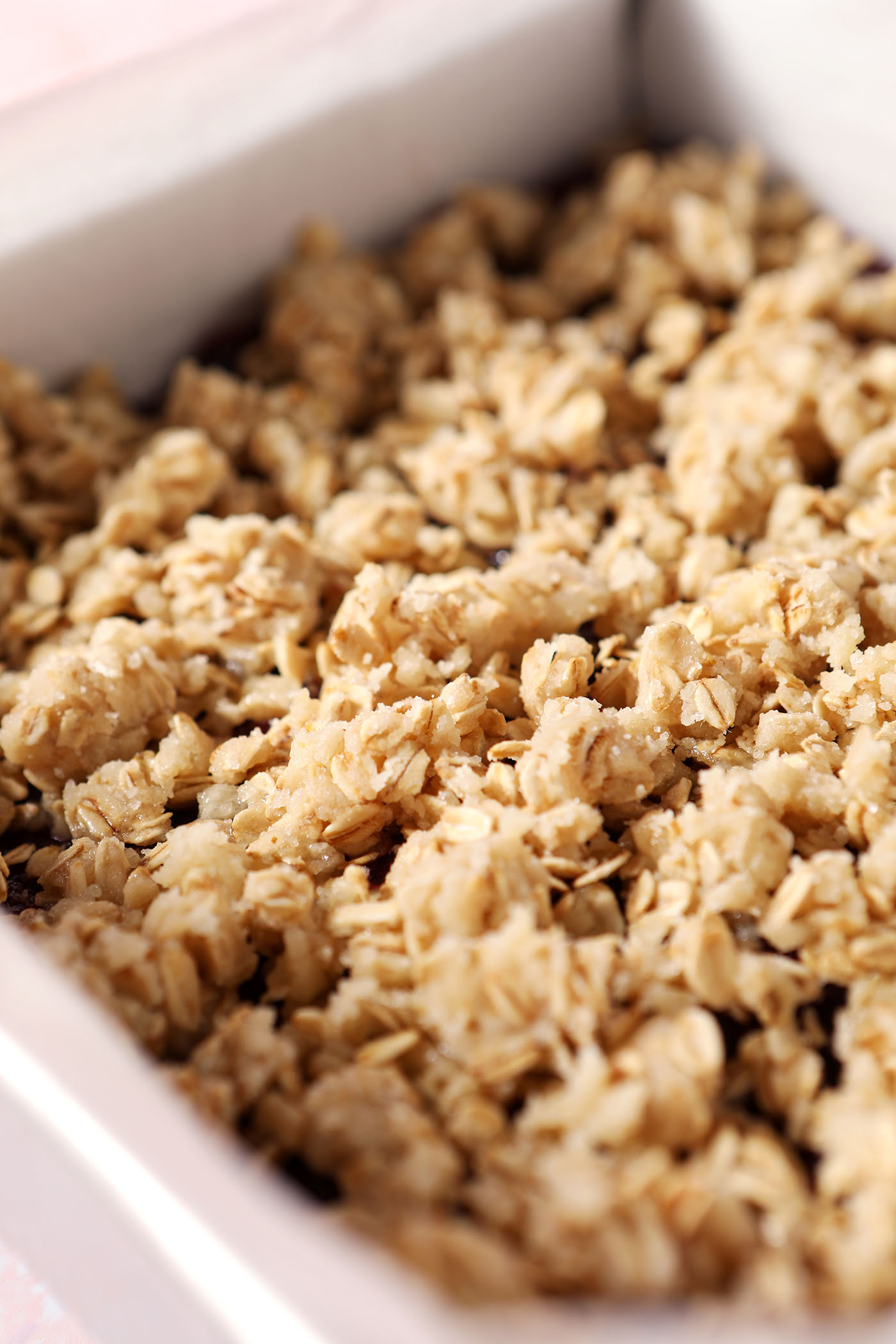 Close up of a crumble topping on top of cranberry bars before baking